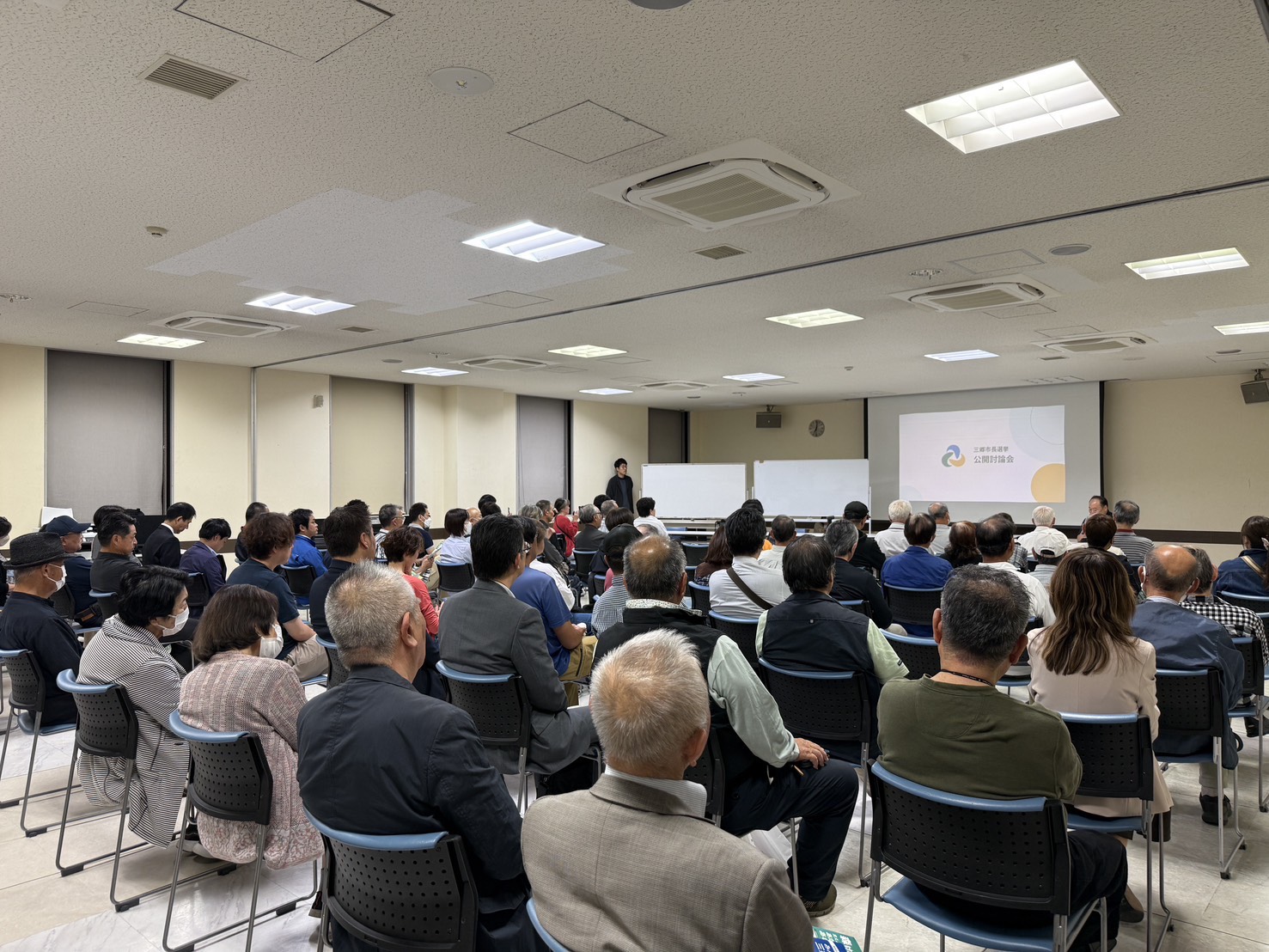 10月13日、鷹野文化センター大会議室で公開討論会に耳を傾ける来場者